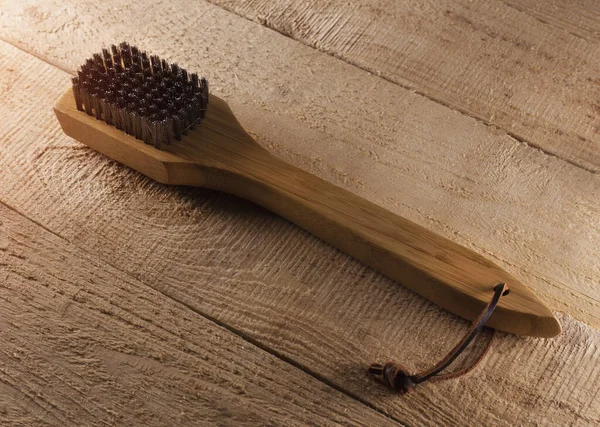 Barbecue grill cleaning brush on rustic wood background — Stock Photo, Image