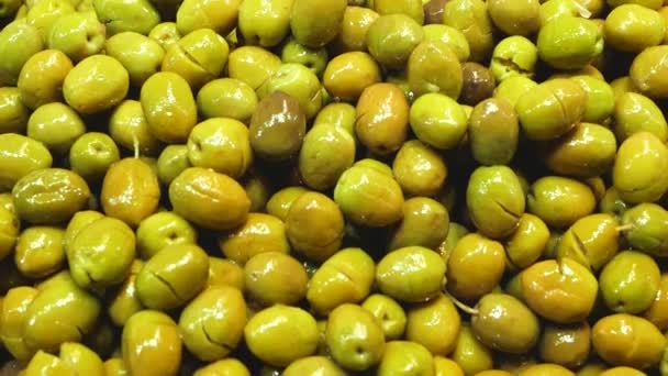 Крупним планом свіжі зелені оливки на ринковій стійці — стокове відео