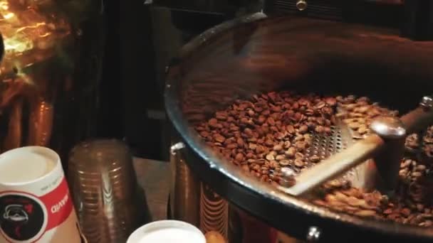 Sült kávét keverek. Kávébab pörkölés a pörkölő berendezésben. A kávébab forog a gépben. — Stock videók