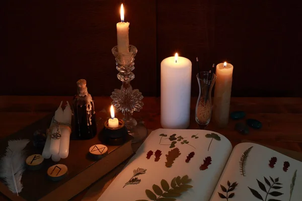 magic ritual of the alchemist with candles, runes and symbols