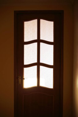 closed door, light shines through, hidden inside