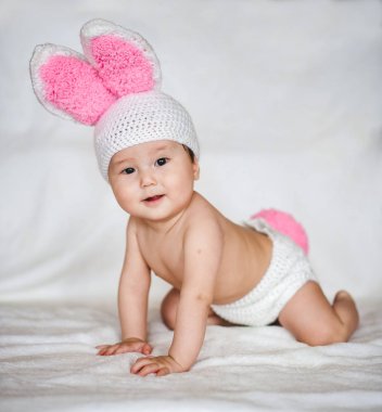 Beyaz arka plan üzerinde tavşan kulaklı şapkalı Asya bebek portresi
