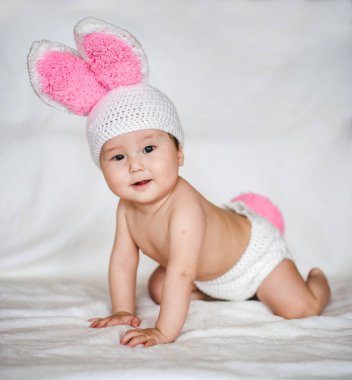 Beyaz arka plan üzerinde tavşan kulaklı şapkalı Asya bebek portresi