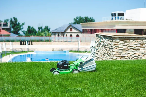 Çim kesici çimenlerin üzerinde arka plan üzerinde havuzlu