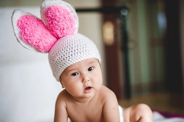 Beyaz arka plan üzerinde tavşan kulaklı şapkalı Asya bebek portresi