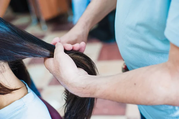 Las Manos Del Peluquero Sostienen Pelo Largo Oscuro Femenino — Foto de Stock