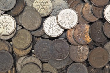 Heap of Japanese coins at 1 yen. News about the economy, finances and interest rate of the central bank of Japan. External and public debt, deflation. View from above. Close-up