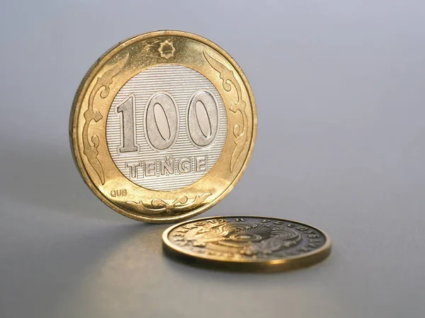 Kazak parası 100 tenge 'de gri bir kağıtta duruyor. İçinde Latince yazıtlar bulunan 2019 tarihli yeni bir serbest bırakma örneğinin madeni parası. Kazakistan 'ın ekonomi ve merkez bankası, yeniden finansman oranı. Makro