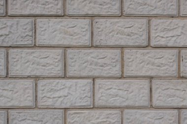 Gri beton bloklardan yapılmış bir evin duvarı. Koyu arkaplan ya da duvar kağıdı. Düşük kontrastlı resim. Binaların yapımı ve onarımı