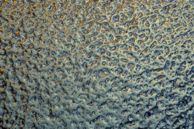 Cıva benzeri buzun mavi-yeşil-sarı yüzeyi. Ufak bir kıvrılma izi. Yoğun bir ormana benziyor. Renk yeşimi ya da morötesi. Soyut kış arkaplanı ya da duvar kağıdı. Soğuk ve soğuk. Yakın plan.