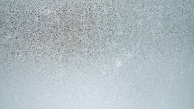 Kışın pencere camında buz ve buz. Hava tahmini: soğuk, buz gibi, serinliyor. Soyut arkaplan ya da yeşilimsi ya da mavimsi bir rengin duvar kağıdı. Zor mevsim