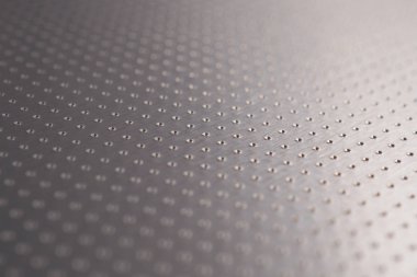 Birçok deliği olan alüminyum yüzey. Safları uzaklaşıyor ve bir perspektif oluşturuyor. Soyut koyu gri metal arka plan veya duvar kağıdı. Makro