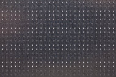 Birçok deliği olan alüminyum yüzey. Soyut koyu gri metal arka plan veya duvar kağıdı. Yukarıdan bak. Makro