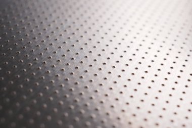 Birçok çentik noktalı alüminyum yüzey. Soyut siyah beyaz metalik arka plan ya da duvar kağıdı. Sıralar halinde dizilmiş noktalar mesafeye gider ve bir perspektif oluşturur. Makro