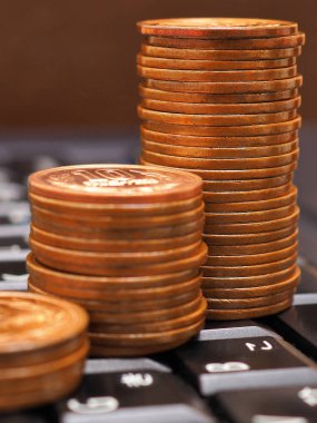 Bir bilgisayar veya dizüstü bilgisayarın siyah klavyesinde 10 yenlik Japon sikkeleri var. Çevrimiçi ticaret, ödemeler ve uzaktan çalışma. Dikey çekim. Makro