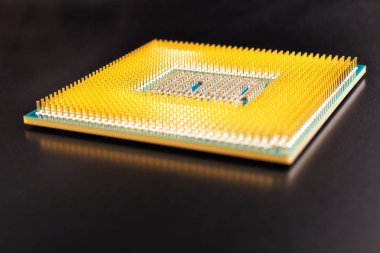 Bir bilgisayar veya dizüstü bilgisayarın işlemci mikroişlemcisi koyu bir mat yüzeyinde yatar. Yakın plan. İşlemci, yarı iletken, pim ve konnektörler. Görüntü: Elektronik ve bilgisayar ekipmanları. Makro