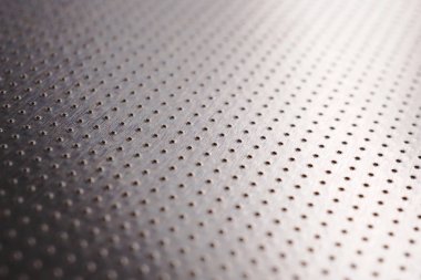 Birçok çentik noktası olan alüminyum metal yüzey. Soyut koyu gri metalik arkaplan ya da duvar kağıdı. Noktalar çizgileri mesafeye gider ve bir perspektif oluşturur. Makro