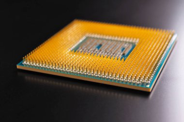 Bir bilgisayarın işlemcisi koyu bir mat yüzeyinde yatar. Yakın plan. İşlemci, yarı iletken, pim ve konnektörler. İllüstrasyon: elektronik ve bilgisayar donanımı, bilgisayar donanımı. Makro
