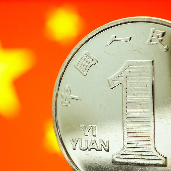 Chinese money. 1 yuan coin on the background of the flag of the China PRC close-up. Economy, national currency exchange rate, devaluation, trade war, one belt one road strategy. Macro