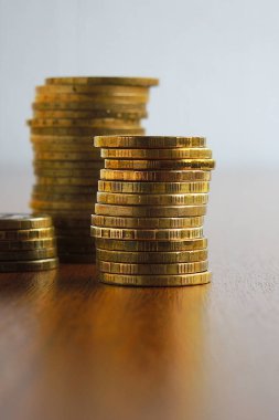 Bir yığın Rus sikkesi kahverengi bir ofis masasının üzerinde duruyor. 10 ruble değerinde. Ekonomi, merkez bankası, yeniden finansman oranı, mevduat, faiz. Dramatik illüstrasyon. Dikey çekim. Makro