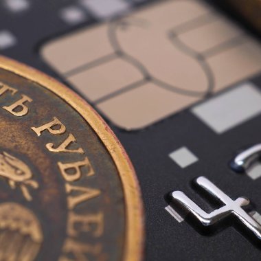 Rus 10 ruble sikkesi siyah plastik bir kartın üzerinde. Yakın plan. Banka kredi ve banka kartı haberleri, çevrimiçi ödemeler, bireylere ve ödeme sistemlerine borç verme. Kare atış. Makro