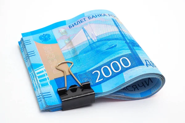 2000 ruble 'lik bir deste Rus banknotu beyaz bir kağıdın üzerinde yatıyor. İzole değil. Mikro kredi ve mikro finans kuruluşları. Tüketici kredileri ve mevduatları. Makro