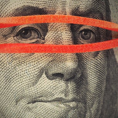 100 dolarlık banknot çok yakın. Franklin 'in yüzü maske gibi lastik bir bantla kaplı. Amerikan ekonomisi ve devalüasyonuyla ilgili haberler. Gözetleme, sade anahtar. Kare atış. Makro