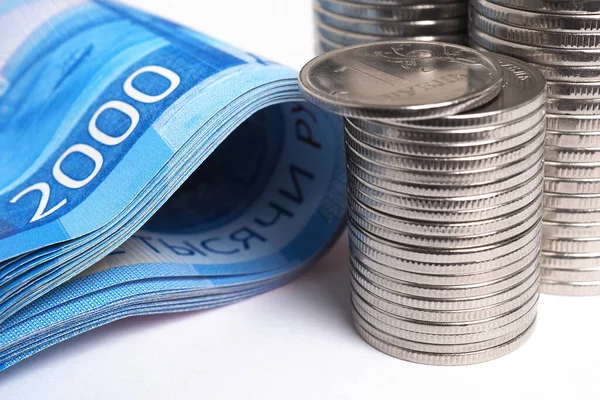 Yığınla Rus sikkesi ve 2000 rublelik banknot çok yakın planda. Rus ekonomisi hakkında haberler, yatırımlar, durgunluk, bankalar, mevduatlar, enflasyon, devalüasyon, dolar döviz kuru. Makro