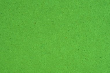 Yeşil karton yüzeyi. Selüloz lifli pürüzlü doğal kağıt dokusu. Parlak doymuş renk. Arkaplan ya da duvar kağıdı. Yukarıdan yukarıdan bir görüntü. Makro