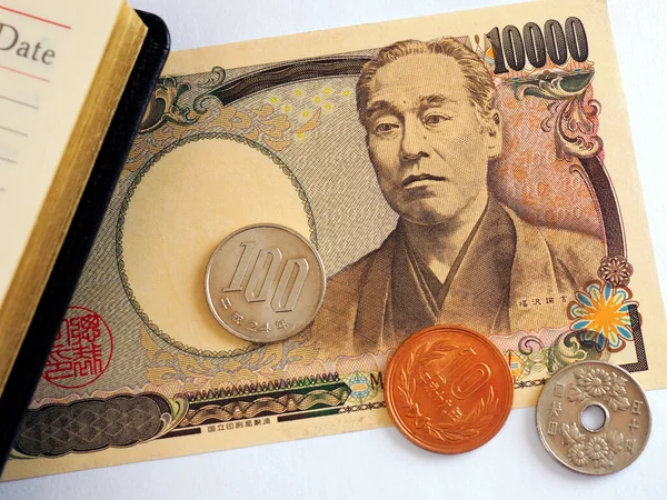 日本のお金 硬貨は 開かれた日記の近くにあります 10000円札のクローズアップ 日本経済に関するニュース 財務管理と意思決定 マクロ — ストック写真