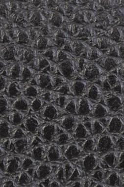 Deri arka plan, siyah, parlak, engebeli, dokulu. Yeniden yapılandırılmış deri. Gerçek doğal materyalin yerine. Karanlık zemin ya da duvar kağıdı. Kontrastı düşürdüm. Dikey çekim. Makro
