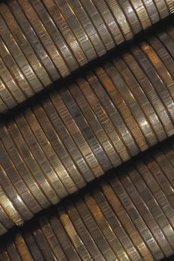 Background from stacks and edges of yellow brass coins placed at an angle diagonally across the image. 10 Russian rubles close up. Dark vertical backdrop or wallpaper on economic, banking topic. Macro clipart