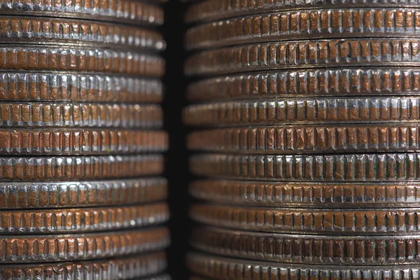 Background from stacks and edges of USA coins of 25 cents in circulation. Wall of American US quarters close-up. Dark textured backdrop or wallpaper on an economic, financial or banking topic. Macro