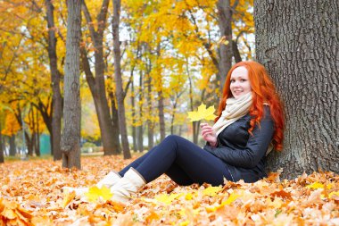 sonbahar ormandaki düşen sarı yapraklar kız otur