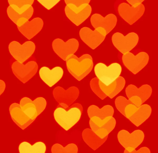 Coração bokeh fundo, foto objetos embaçados, amarelo no vermelho — Fotografia de Stock