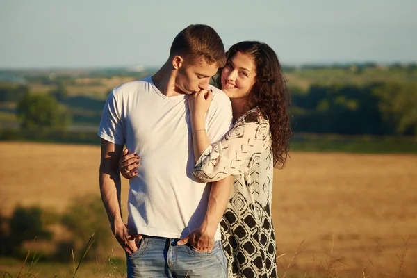 Щаслива молода пара високо позує на кантрі над жовтим полем, концепція романтичних людей, літній сезон — стокове фото