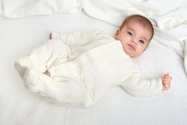 Baby on white towel in bed — Stock Photo, Image