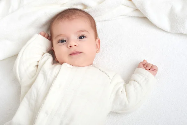 Baby portrait lie on white towel in bed — Stock Photo, Image