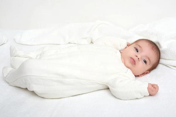 Baby on white towel in bed — Stock Photo, Image