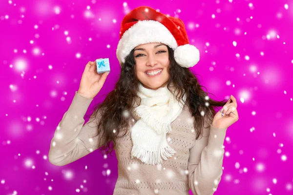 Ragazza in ritratto di Babbo Natale con piccola scatola regalo in posa su sfondo di colore rosa, concetto di festa di Natale, felice ed emozioni — Foto Stock