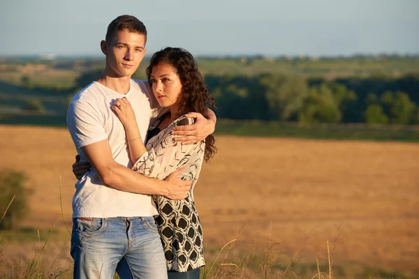 Jovem casal posando no país ao ar livre à noite, conceito romântico e ternura, temporada de verão — Fotografia de Stock