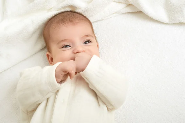 Baby portait lie on white towel in bed, yellow toned — Stock Photo, Image