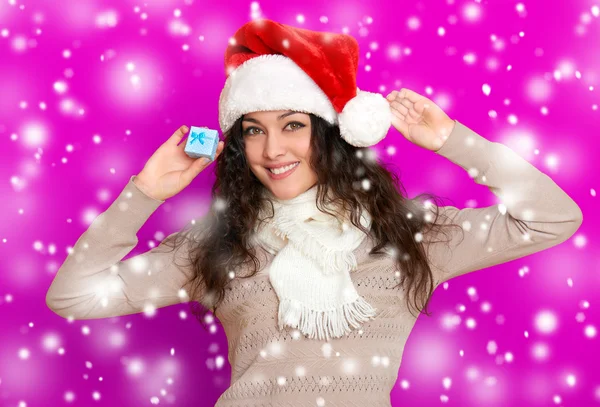 Ragazza in ritratto di Babbo Natale con piccola scatola regalo in posa su sfondo di colore rosa, concetto di festa di Natale, felice ed emozioni — Foto Stock