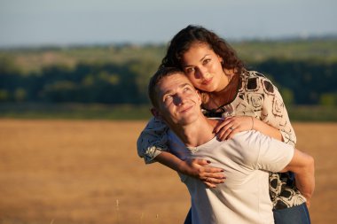 Hiking, tatil, sevgi ve dostluk kavramı - gülümseyen kaç akşam gökyüzü arka plan, yaz sezonu, kız adamın tesisi üzerinde eğleniyor önce