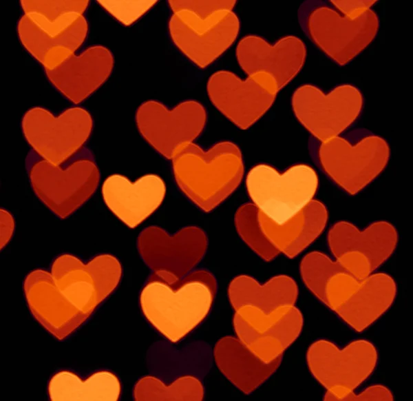 Heart bokeh background, photo blurry objects, brown red on black — Stock Photo, Image