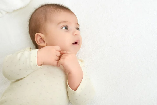 Babyportait liegt auf weißem Handtuch im Bett, gelb getönt — Stockfoto