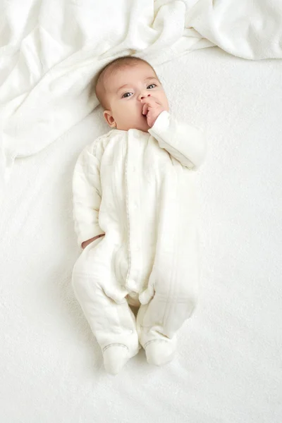 Baby portait lie on white towel in bed, yellow toned — Stock Photo, Image