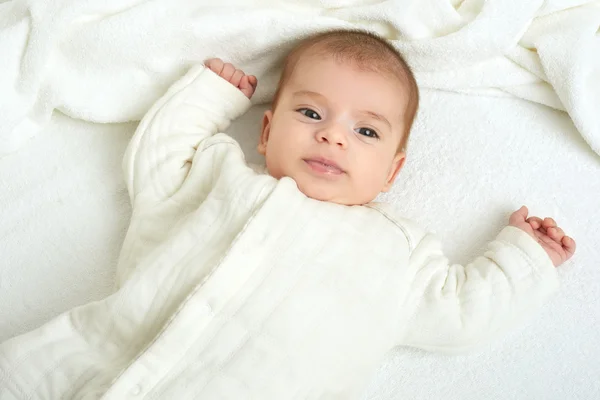 Babyportait liegt auf weißem Handtuch im Bett, gelb getönt — Stockfoto