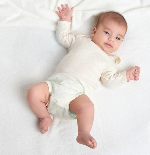 Baby lie on white towel in bed, top view — Stock Photo, Image