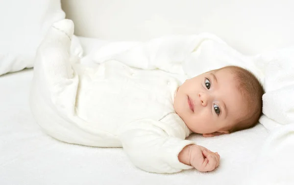 Baby auf weißem Handtuch im Bett, gelb getönt — Stockfoto